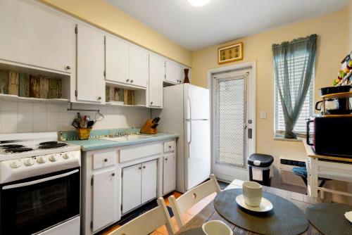 a kitchen with white cabinets and a table with a dining room at Sunny 1BR Hollywood Retreat – Pet Friendly in Hollywood
