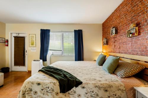 a bedroom with a large bed with a brick wall at Sunny 1BR Hollywood Retreat – Pet Friendly in Hollywood