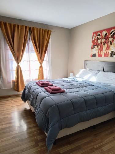 a bedroom with a bed with a blue blanket on it at Puerta Sur Apart in Malargüe