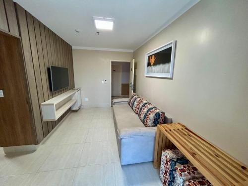 a living room with a couch and a flat screen tv at Piazza DiRoma com acesso ao Acqua Park todos os dias in Caldas Novas
