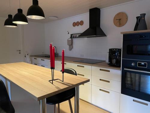 SyðrugøtaにあるCozy apartment in beautiful Syðrugøtaのキッチン(木製テーブル、赤いキャンドル付)
