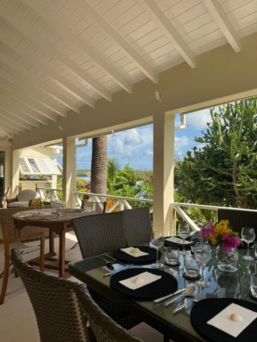 a dining room with tables and chairs on a patio at East End Antigua Boutique Hotel in Willikies