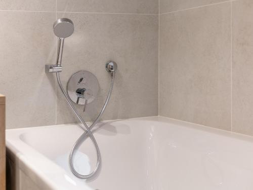 a shower in a bathroom with a white tub at Alpenlodge Pettneu Lodge XL in Pettneu am Arlberg