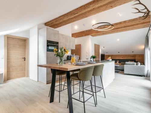 a kitchen and living room with a table and chairs at Alpenlodge Pettneu Lodge XL in Pettneu am Arlberg