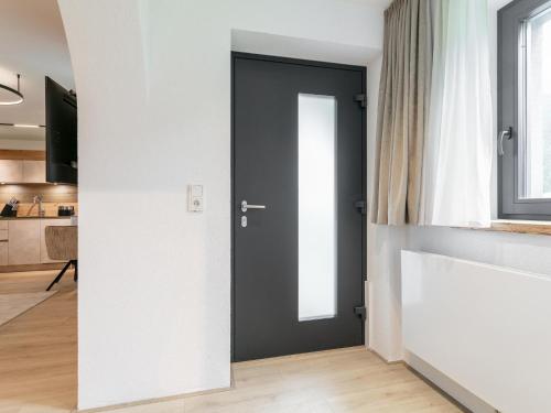 a black door in a white room with a kitchen at Alpenlodge Pettneu Lodge XL in Pettneu am Arlberg