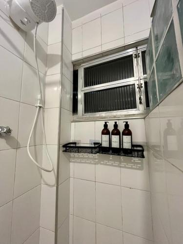 Studio Brisa - Vista Mar Canal 5 - Santos في سانتوس: حمام به ثلاث زجاجات من النبيذ على رف