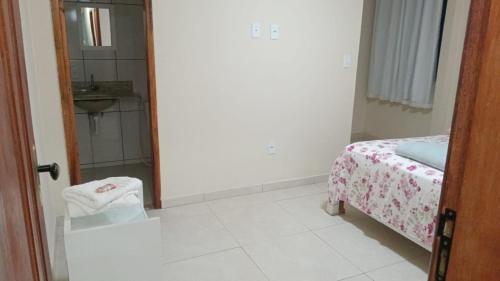 a room with a bed and a bathroom with a mirror at Refúgio da Light in Carmo