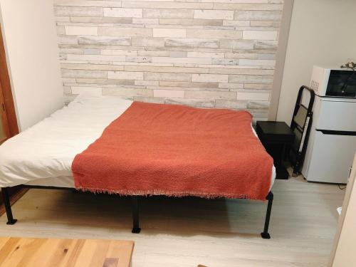 a bed with a red blanket on it in a room at Station Front JUSO EAST 402 No Lift in Osaka