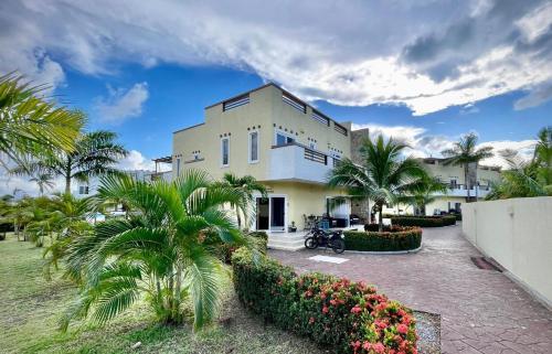 a building with palm trees in front of it at Las Palmas villa two bedrooms in Roatan