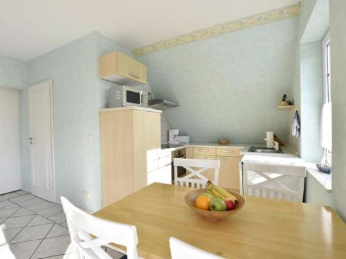 a kitchen with a wooden table with a bowl of fruit on it at Nordlicht - Windjammer in Timmendorf