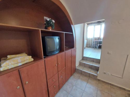 a living room with a tv on a wooden cabinet at Crab's Original Apartment 2 in Vrontados