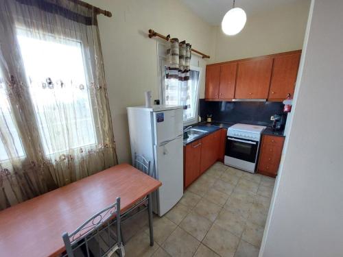 a small kitchen with a table and a refrigerator at Crab's Original Apartment 2 in Vrontados