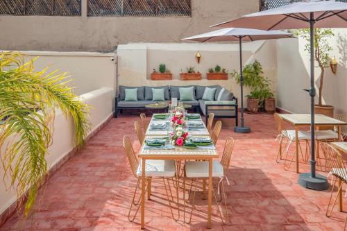 a patio with a table and chairs and a couch at Riad Akasia in Marrakech