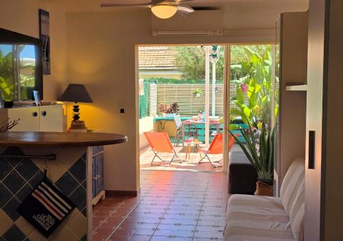 Il dispose d'une cuisine et d'un salon avec vue sur un patio. dans l'établissement Grand Studio aux Salins - climatisation - terrasse - 90m de la mer, à Hyères