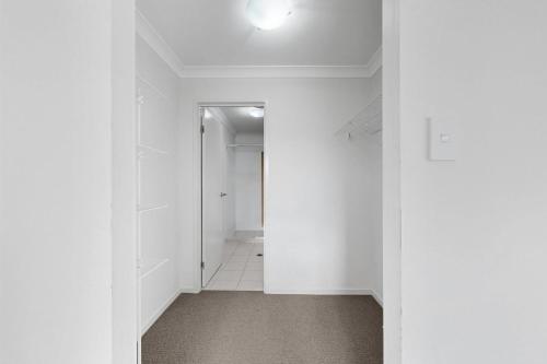 北湖Modern Homely Townhouse with Pool Access & Free WIFI的空的走廊,有白色的墙壁和天花板