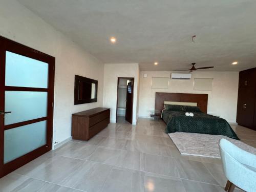 a bedroom with a bed and a dresser in it at Beach Getaway in Chuburná
