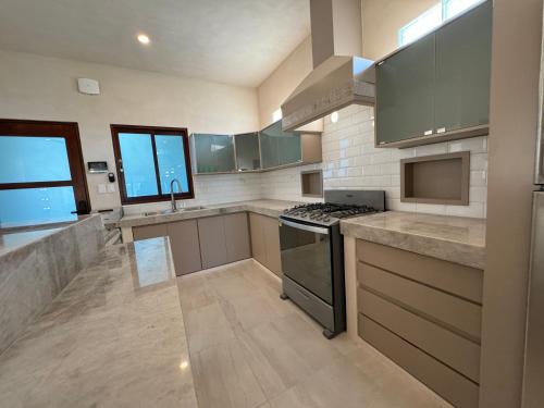 a large kitchen with stainless steel appliances and gray cabinets at Beach Getaway in Chuburná