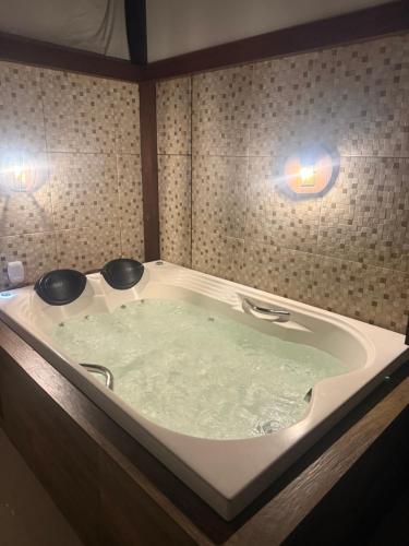 a large bath tub with two lights in a bathroom at Temporada Ilhéus 2/4 in Ilhéus