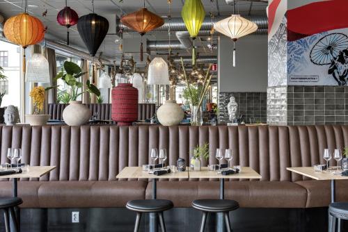 a restaurant with a large wooden partition with tables and stools at Comfort Hotel Göteborg in Gothenburg