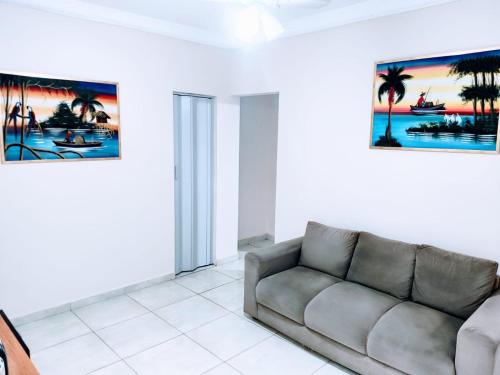 a living room with a couch and a painting on the wall at Apartamento Maravilhoso 2 Quartos Suíte Privativa no Boqueirão em Santos in Santos