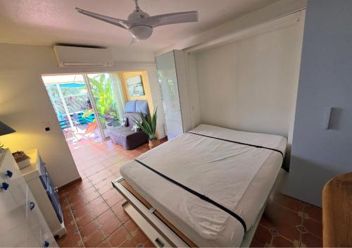 une chambre avec un lit et un salon dans l'établissement Grand Studio aux Salins - climatisation - terrasse - 90m de la mer, à Hyères