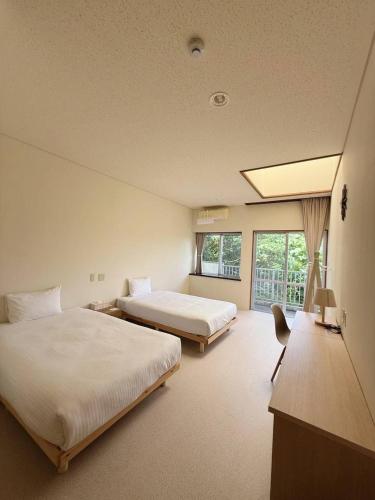 a hotel room with two beds and a window at 海王屋 Kaioya in Fukai