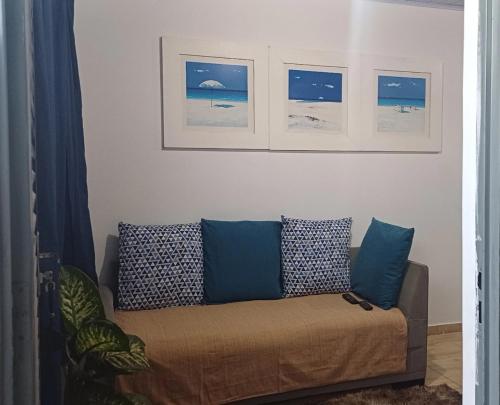a couch in a living room with pictures on the wall at Harmonia em sintonia in Alto Paraíso de Goiás