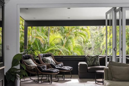 a living room with chairs and a large window at Arya in Byron Bay
