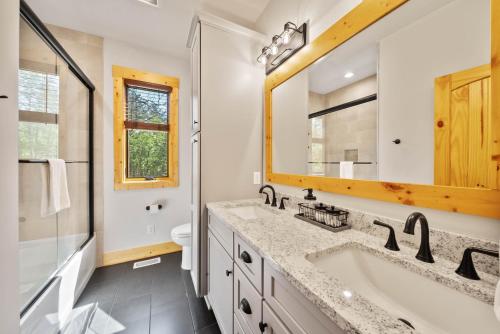 un baño con lavabo y espejo en Buddys Cabin, en Banner Elk