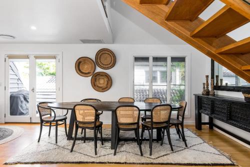 a dining room with a black table and chairs at A Top Spot in Byron Bay
