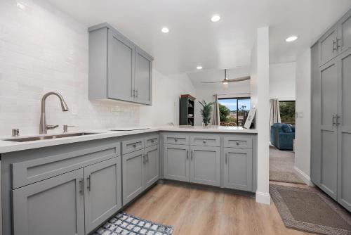 a kitchen with white cabinets and a sink at Tranquil Living - SUR4 in Solana Beach