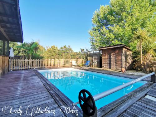 une piscine avec une terrasse en bois et une clôture dans l'établissement 2164 Zemmar, à Aire-sur-lʼAdour
