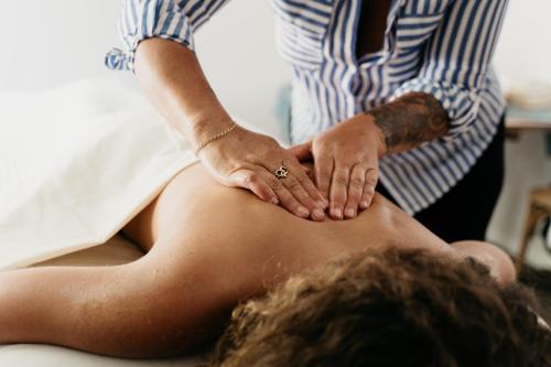 a woman getting a massage from a woman sitting on a couch at Cross Hill Glamping in Lake Hawea