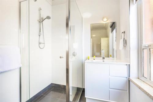 a white bathroom with a shower and a sink at Nightcap at Rose & Crown Hotel in Elizabeth