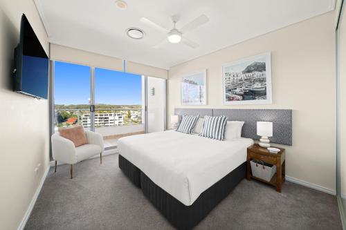 a bedroom with a bed and a large window at Mantra The Observatory in Port Macquarie