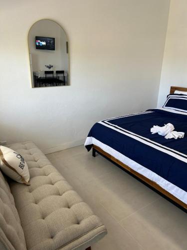 a bedroom with a bed and a couch and a mirror at Luxury 7BR 5BA Oceanview Villa Altrui - Sleeps up to 18 in Saint Marks Village