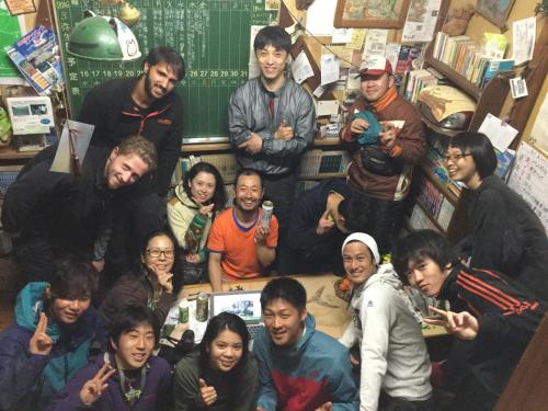 a group of people posing for a picture in a classroom at Tomarigi in Yakushima
