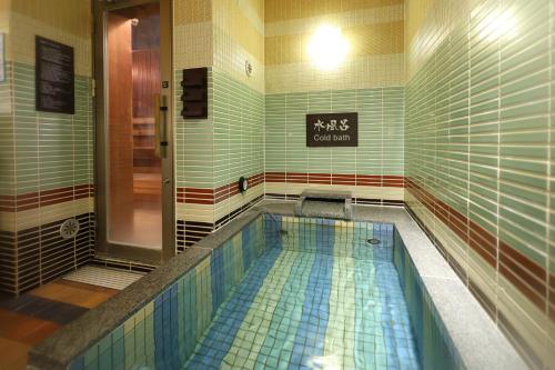 大阪多美迎PREMIUM难波酒店的地板破损的浴室里有个游泳池