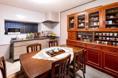 a kitchen with a wooden table and a dining room at 小景汤布院日式传统温泉民宿 in Yufuin