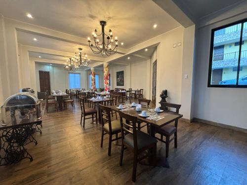 a dining room with tables and chairs and a chandelier at Pascana Hotel in Chivay