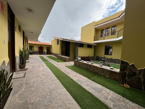 a courtyard of a house with green grass at Pascana Hotel in Chivay