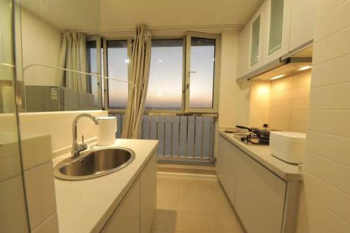 a kitchen with a sink and a large window at Shanghai Hills & Wanda Side Spacious Stay Close to Metro Line 18 in Shanghai