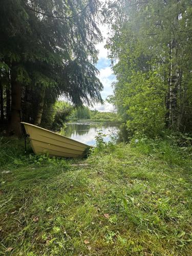 a boat sitting on the grass next to a lake at Merikarviantupa1 in Pori