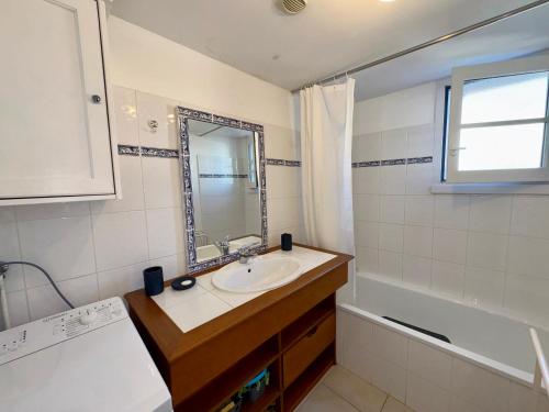 une salle de bain avec un lavabo, un miroir et une baignoire dans l'établissement Maison de Vacances Idéale: Proche Mer, Golf et Thalasso, Jardin Privatif, 6 Pers, Parking Inclus - FR-1-323-364, à Saint-Jean-de-Monts