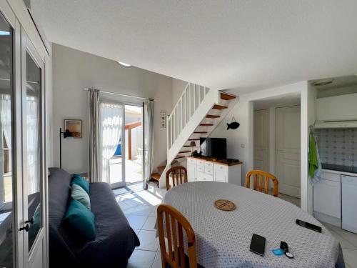 un salon avec une table et un canapé dans l'établissement Maison de Vacances Idéale: Proche Mer, Golf et Thalasso, Jardin Privatif, 6 Pers, Parking Inclus - FR-1-323-364, à Saint-Jean-de-Monts