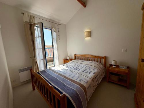 une chambre avec un grand lit et une fenêtre dans l'établissement Maison de Vacances Idéale: Proche Mer, Golf et Thalasso, Jardin Privatif, 6 Pers, Parking Inclus - FR-1-323-364, à Saint-Jean-de-Monts