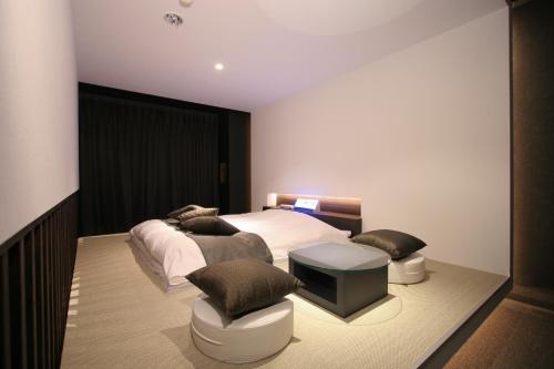 a bedroom with a bed with two pillows and a table at Princes Princes Shiojirikita in Matsumoto
