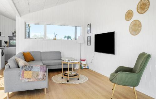 a living room with a couch and two chairs and a tv at Nice Home In Jerup With Sauna in Jerup