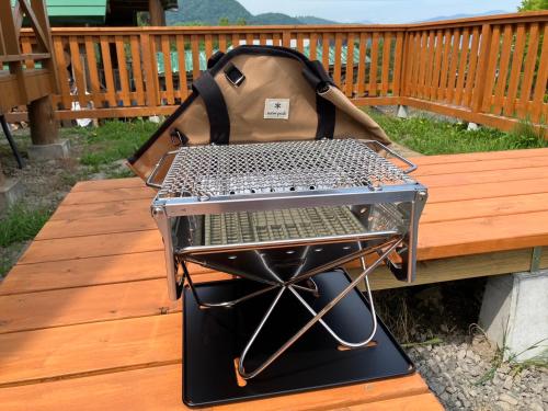 a grill with a bag sitting on a wooden bench at Lake Toya Moon Hills in Lake Toya