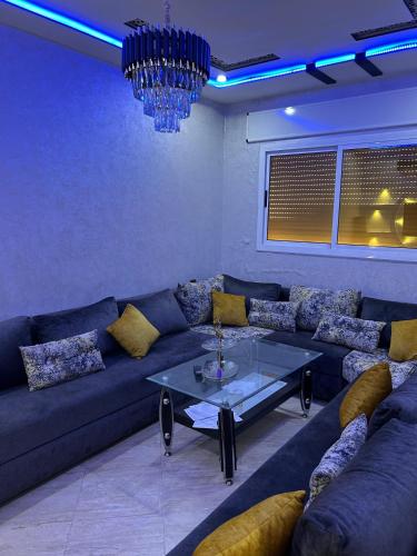 a living room with a couch and a glass table at appartement place mecca in Larache